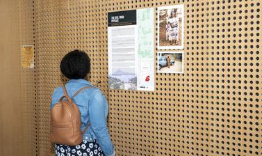 woman looks at poster on a wooden wall