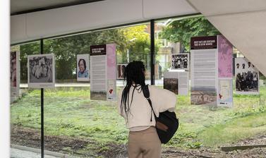 woman looks at poster on the window