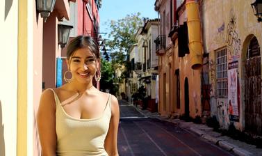 Deshna Shah smiles in front of a sunny street background