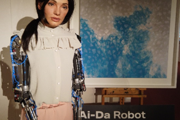 AiDa the robot standing next to her painting