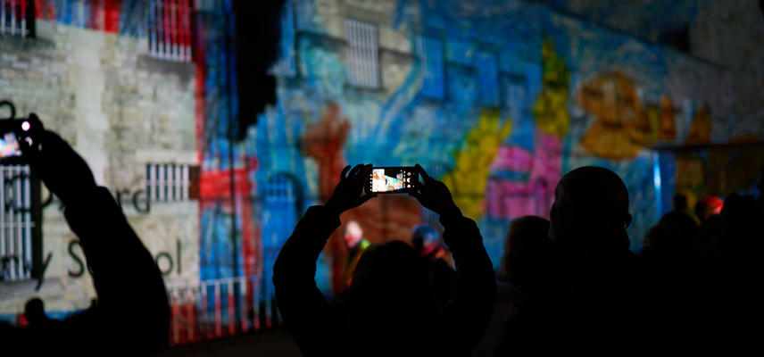 Projection on the side of Oxford castle, with audience taking photos.