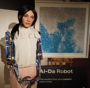 AiDa the robot standing next to her painting