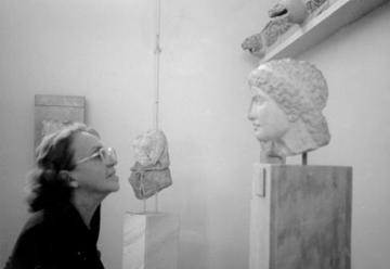 Sophia de Mello Breyner Andresen face to face with the head of a statue in a museum.