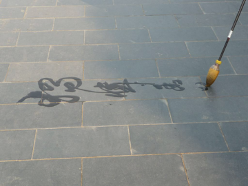 chinese characters being written by a brush on stones