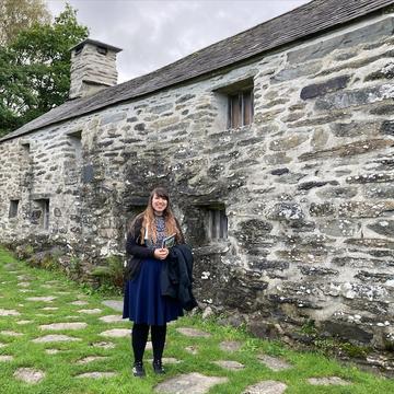 Karina at Tŷ Mawr Wybrnant, standing beside a stone farmhouse building