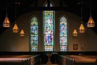 Stained glass window in dark church 